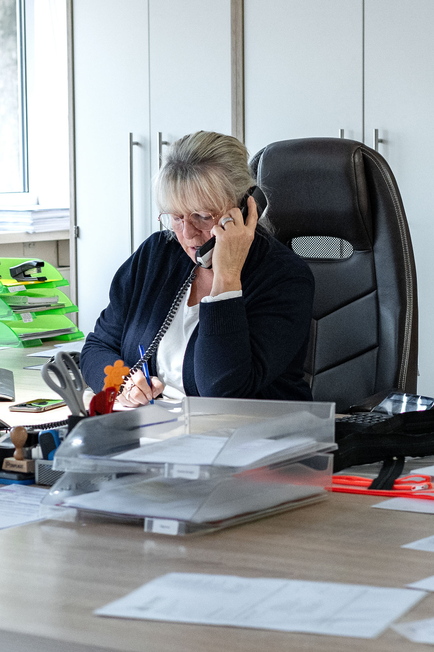 Shot of pretty young woman using her mobile phone while working with laptop sitting on the floor at home.